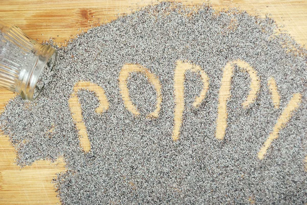 Poppy seeds on a wooden board — Stock Photo, Image