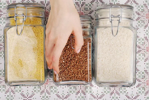 Girl chooses  jars with  cereals — Stock Photo, Image