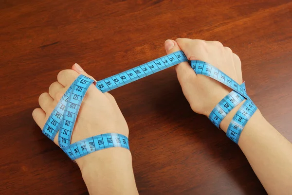 Beautiful hand of a young girl and measuring tape — Stock Photo, Image