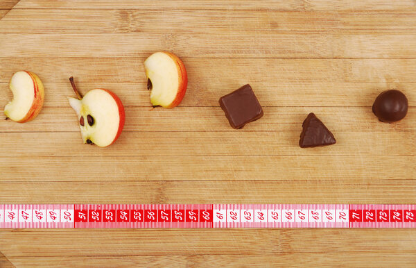 Конфеты и линейка на деревянной доске
