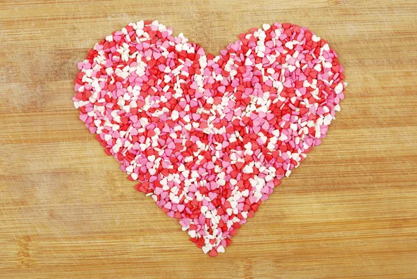 Corazón de corazones pequeños en una tabla de madera — Foto de Stock