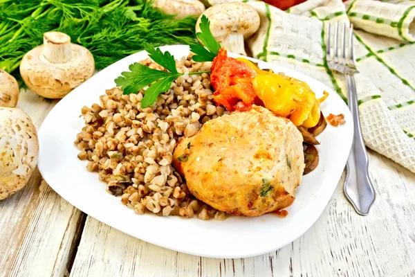 Cutlets of turkey with buckwheat in plate on board — Stock Photo, Image