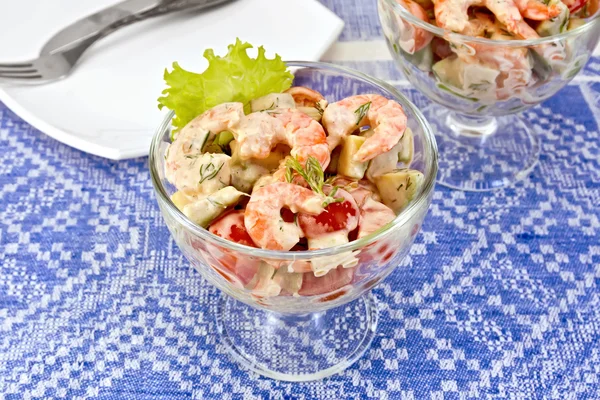 Salad with shrimp and tomatoes in glass on blue tablecloth — Stock Photo, Image