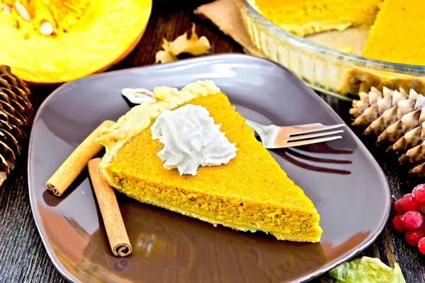 Pie pumpkin in plate with whipped cream on board — Stok fotoğraf