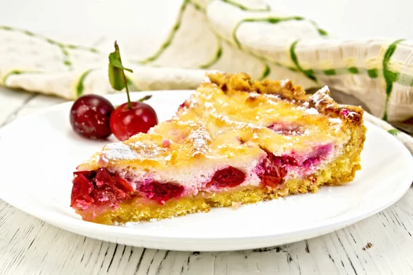 Пирог вишня со сметаной в тарелке на светлой доске — стоковое фото