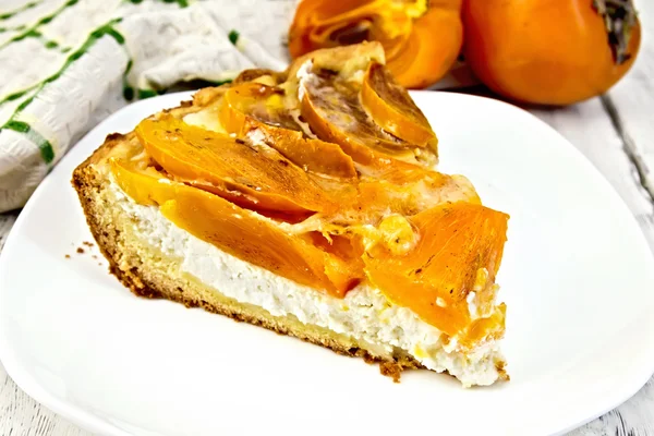 Tarte avec caillé et kaki dans une assiette à bord — Photo