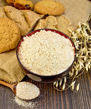 Flour oat in bowl with bread on board clipart