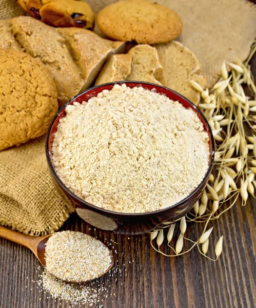 Flour oat in bowl with bread on board — Stock Photo, Image