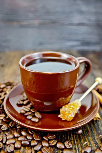 Кофе в коричневой чашке с сахаром и зерном на борту — стоковое фото