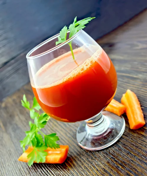 Juice carrot in wineglass on dark board — Stock Photo, Image