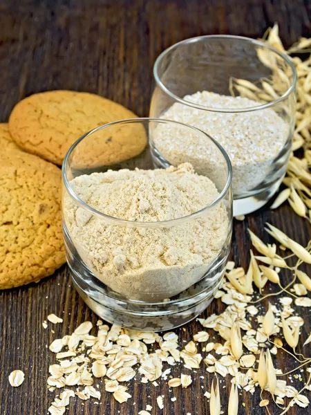 Flour and bran oat in glass with cookies on board — Stock Photo, Image