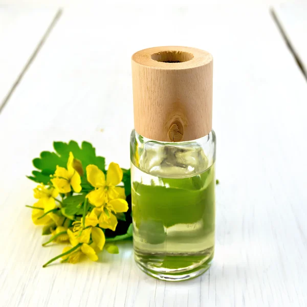 Oil with celandine on light board — Stock Photo, Image