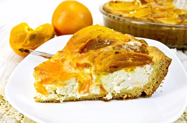 Tarta con cuajada y caquis en placa sobre servilleta de silicona y boa —  Fotos de Stock