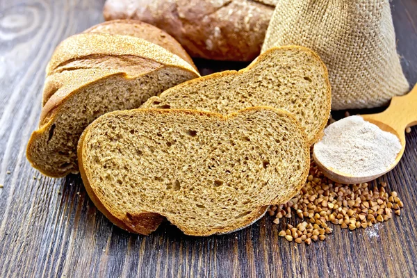 Bread buckwheat with cereals and flour in spoon on board — Stock Photo, Image