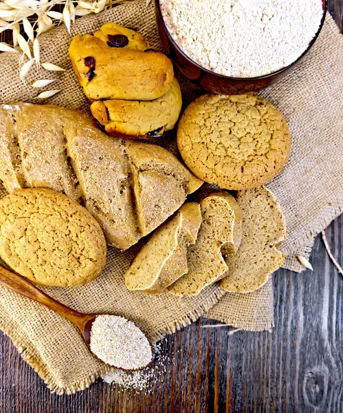 Koyu tahta üstünde ekmek ve bisküvi yulaf unu — Stok fotoğraf