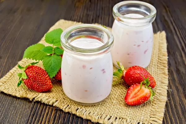 Yogurt with strawberries in jars on sacking — Stock Photo, Image