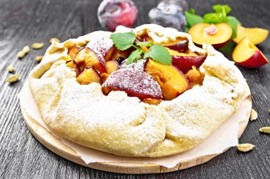 Erikli tatlı turta, parşömen üzerinde kakule, tahta zeminde yeşil nane filizi.