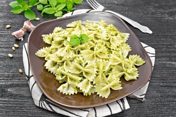 Makaron Farfalle Pesto Bazylia Talerzu Ręczniku Przeciwko Ciemnej Drewnianej Desce — Zdjęcie stockowe