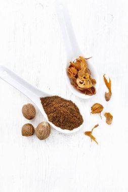 Hindistan cevizi ve kurutulmuş hindistan cevizi arillus iki kaşık içinde, beyaz tahta bir arka planda, yukarıdan gelen fındıklar.