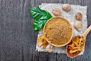 Kâsede hindistan cevizi ve kaşıkta kurutulmuş hindistan cevizi, yukarıdan siyah tahta arka planda çuval bezi.