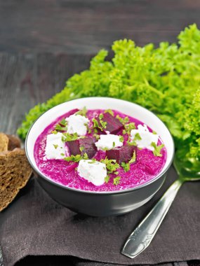 Pancar püresi, patates ve krema ile peçete, ekmek ve maydanoz kaplı bir kasede tuzlanmış krem peynir ahşap bir arka planda.