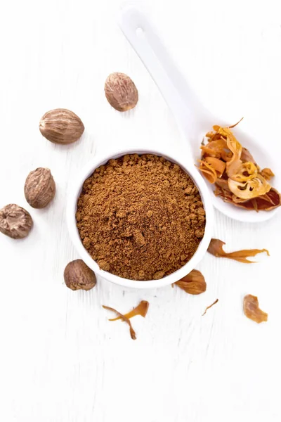 Bir kasede hindistan cevizi ve kaşıkta kurutulmuş hindistan cevizi, yukarıdan hafif tahta arka planda fındık.