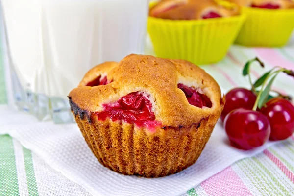 Cupcake with cherries and milk on napkin — Stock Photo, Image