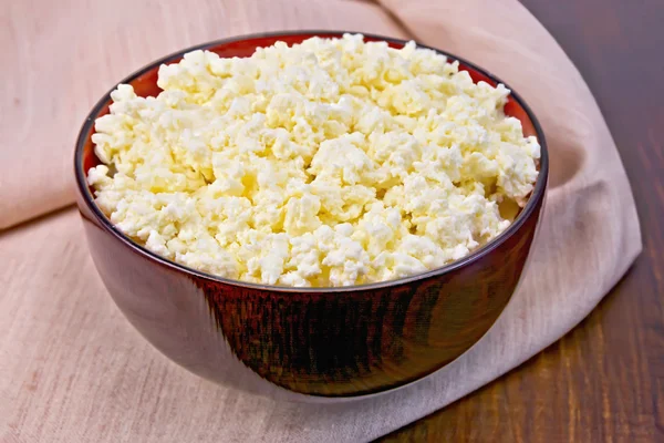 Curd in wooden bowl on board with cloth — Stock Photo, Image