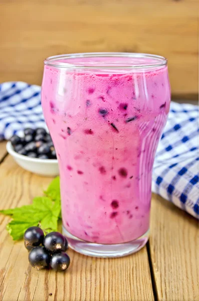 Milkshake with black currants and napkin on board — Stock Photo, Image