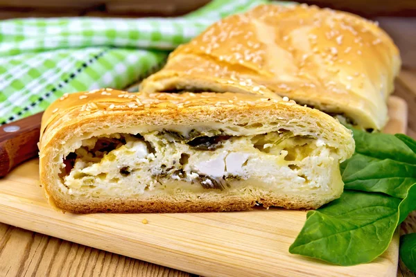 Roll filled with spinach and cheese on board — Stock Photo, Image
