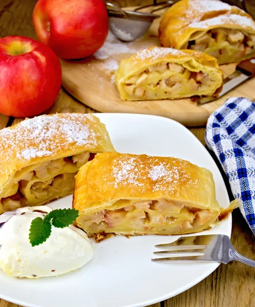 Strudel with apples and ice cream with napkin on board — Stock Photo, Image