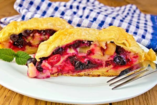 Strudel with black currants and napkin on board — Stock Photo, Image