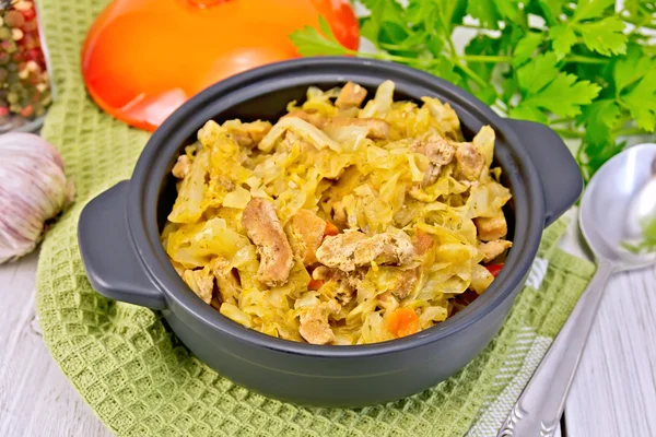 Cabbage stew with meat in black pot on napkin — Stock Photo, Image