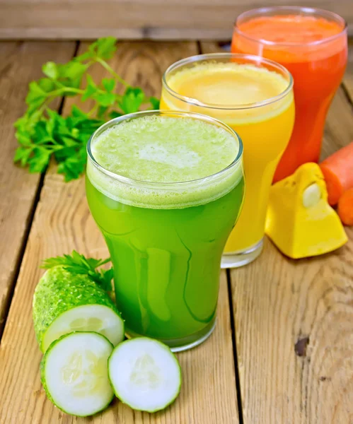 Juice grönsak i tre glas på träplatta — Stockfoto