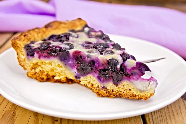 Pie with blueberries and spoon in plate on board — Stock Photo, Image