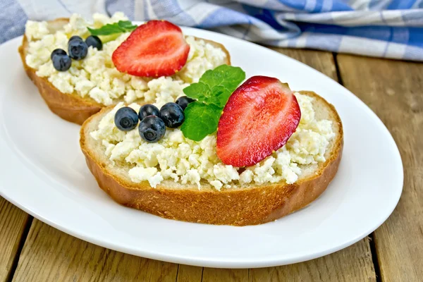 Bread with curd and berries in plate on board — Stock Photo, Image