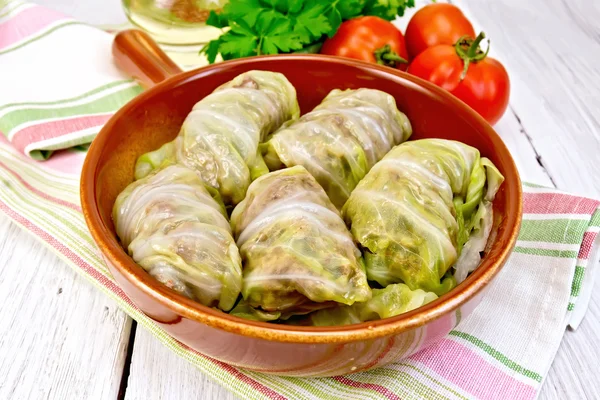 Cabbage stuffed and carrots in ceramic pan on board — Stock Photo, Image