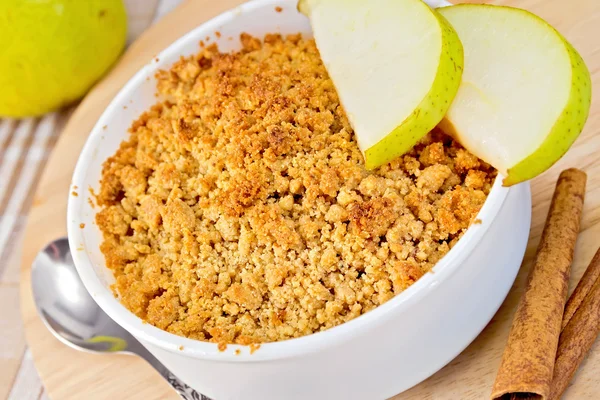 Crumble with pears in bowl on linen tablecloth and board — Stock Photo, Image