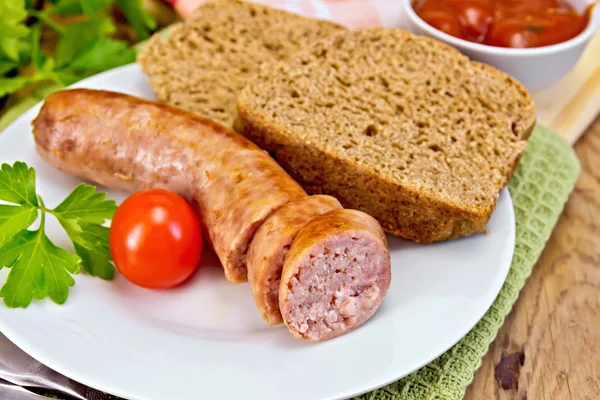 Salsicce di maiale grigliate in piattino con pane a bordo — Foto Stock