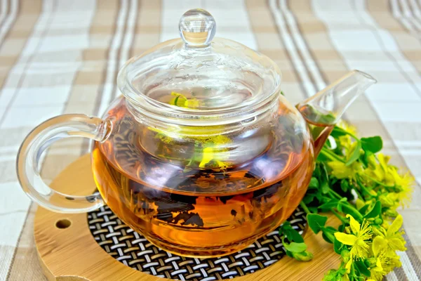 Herbal tea from tutsan in glass teapot on linen tablecloth — Stock Photo, Image