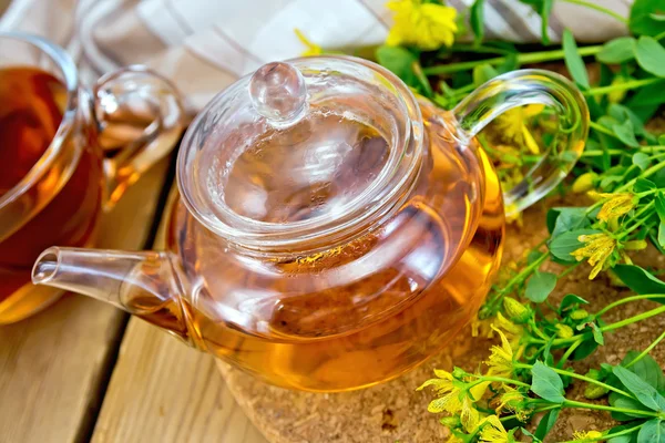Chá de ervas de tutsan em bule de vidro com xícara a bordo — Fotografia de Stock