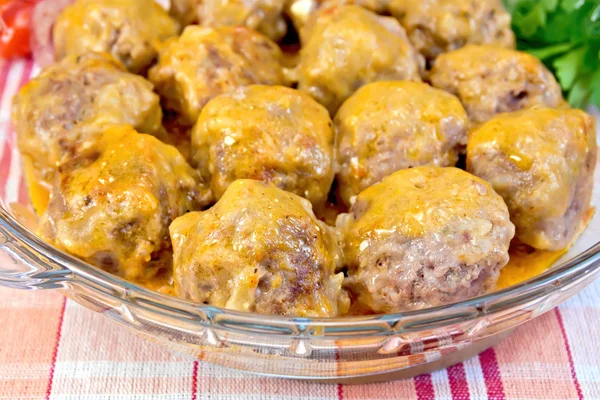 Meatballs with sauce in glass pan on tablecloth — Stock Photo, Image