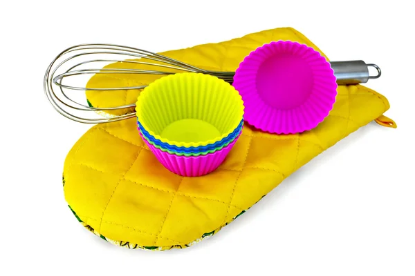 Molds for cupcakes with mixer on yellow potholder — Stock Photo, Image