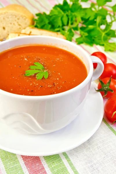 Minestra di pomodoro in ciotola con pomodori su tovagliolo di lino — Foto Stock