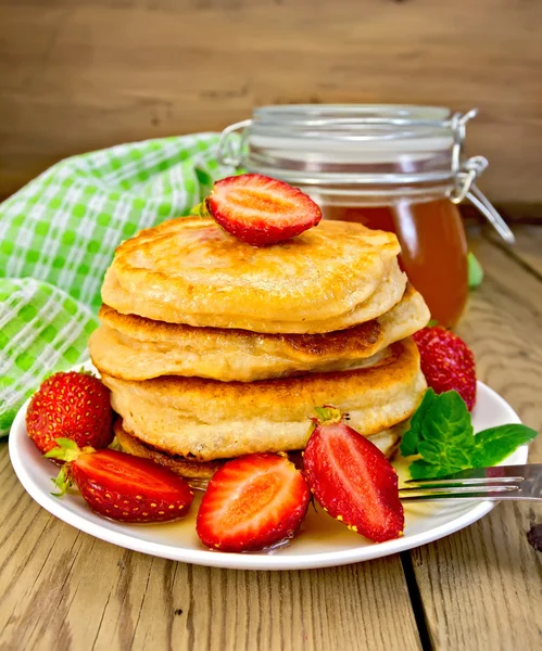 Flapjacks with strawberries and honey on board — Stock Photo, Image