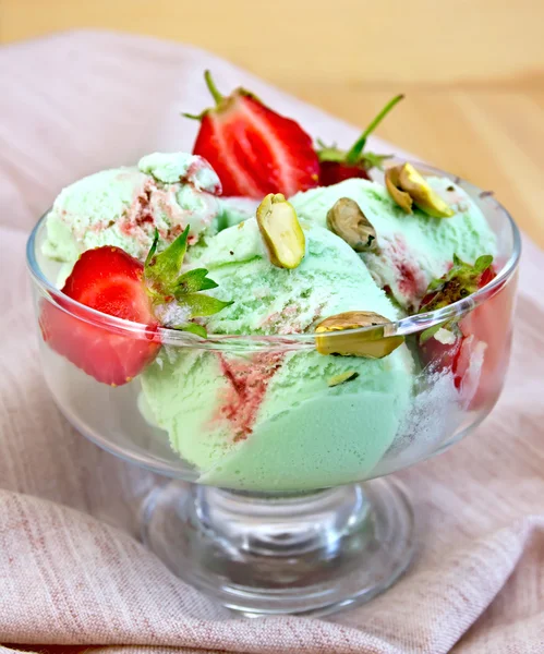 Ice cream strawberry-pistachio on napkin and board — Stock Photo, Image
