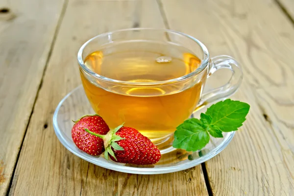 Thee met aardbeien en mint aan boord — Stockfoto