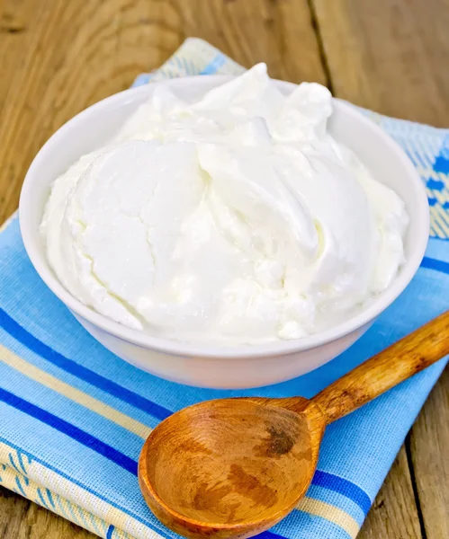 Yoghurt in witte kom met lepel aan boord — Stockfoto