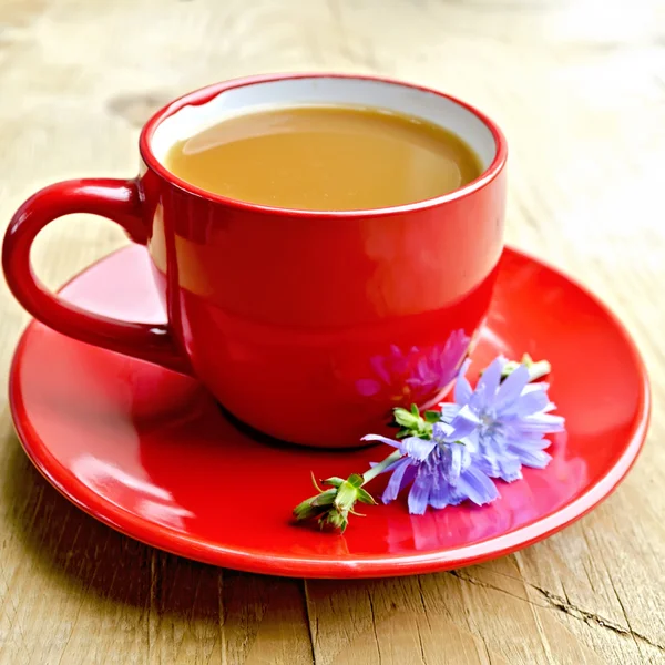 Цикорійський напій у червоній чашці з квіткою на дошці — стокове фото
