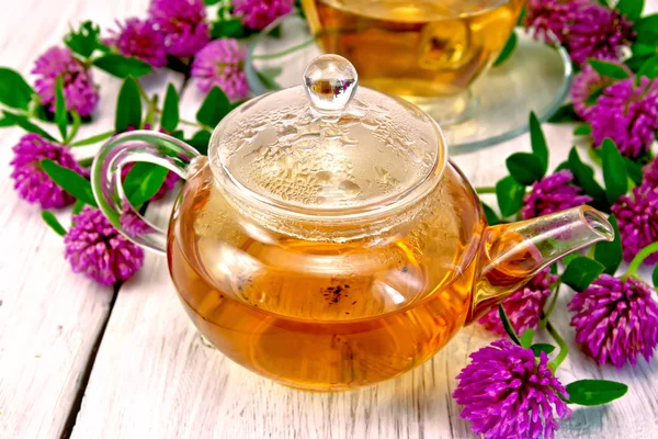 Tea with clover in glass teapot on light board — Stock Photo, Image